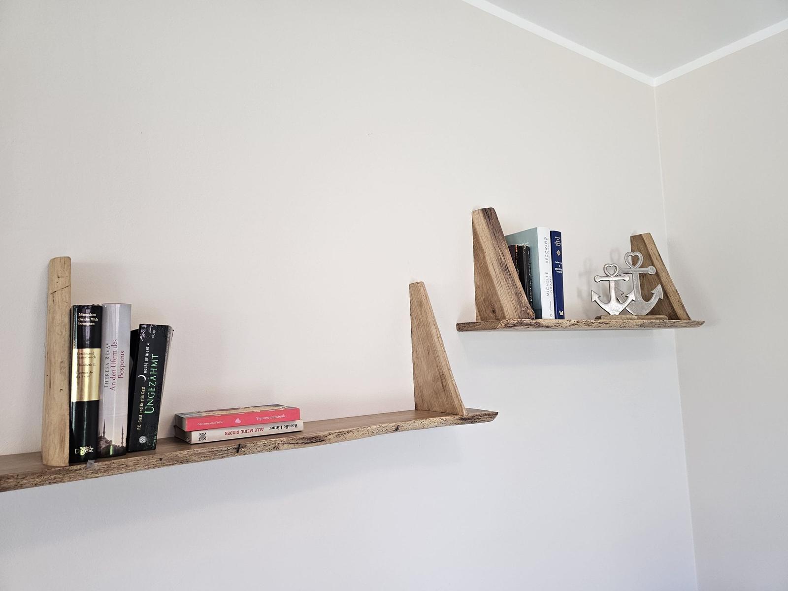 Zwei Holzregale an der Wand mit Büchern und einem Ankerdekoration.