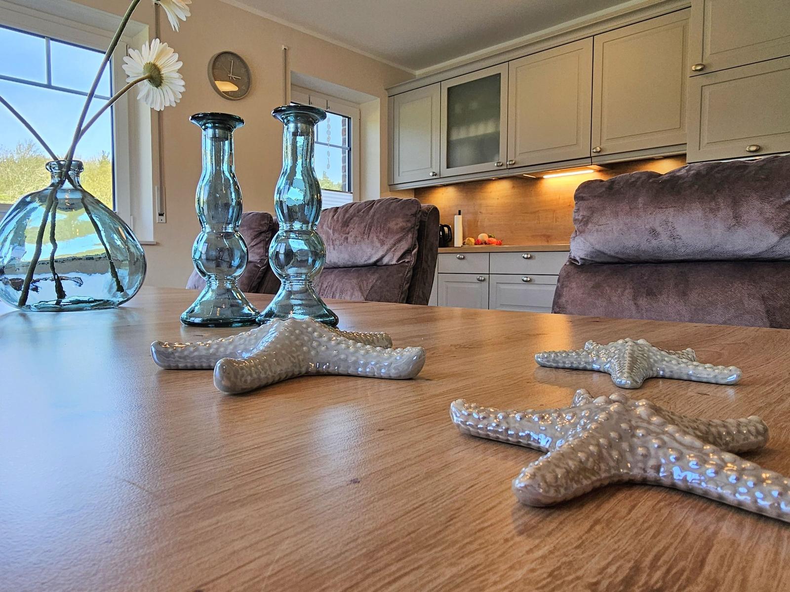 Holztisch mit Seesternen, Vasen und Sitzgelegenheiten im Wohnbereich