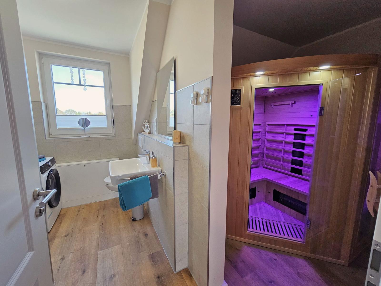 Badezimmer mit Sauna, Waschmaschine und Fenster.
