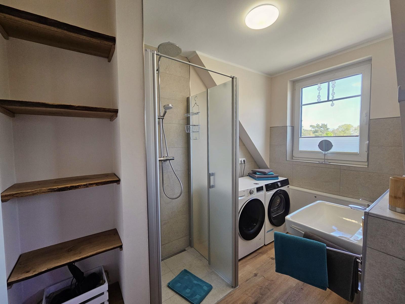 Bad mit Dusche, Waschmaschine und Fenster