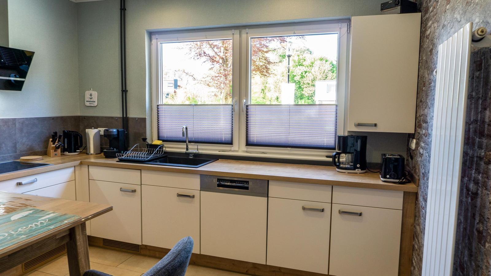 Küche mit Fenster, Spüle, Küchenspüle und Arbeitsfläche.