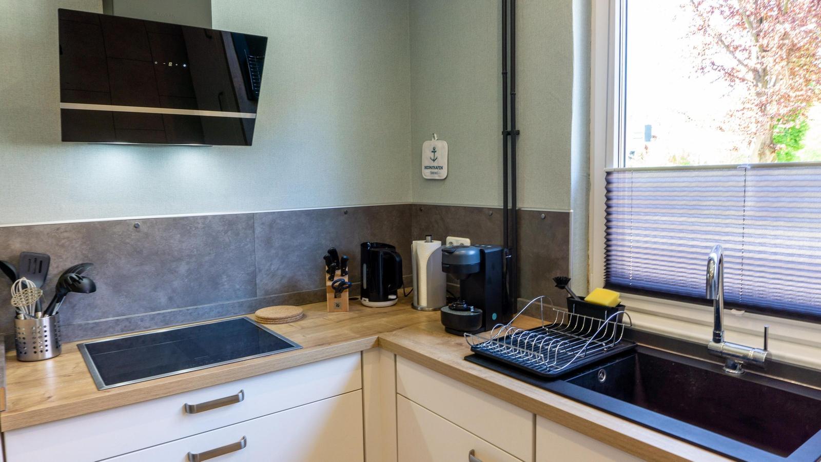 Küche mit Induktionskochfeld, Spüle und Fenster