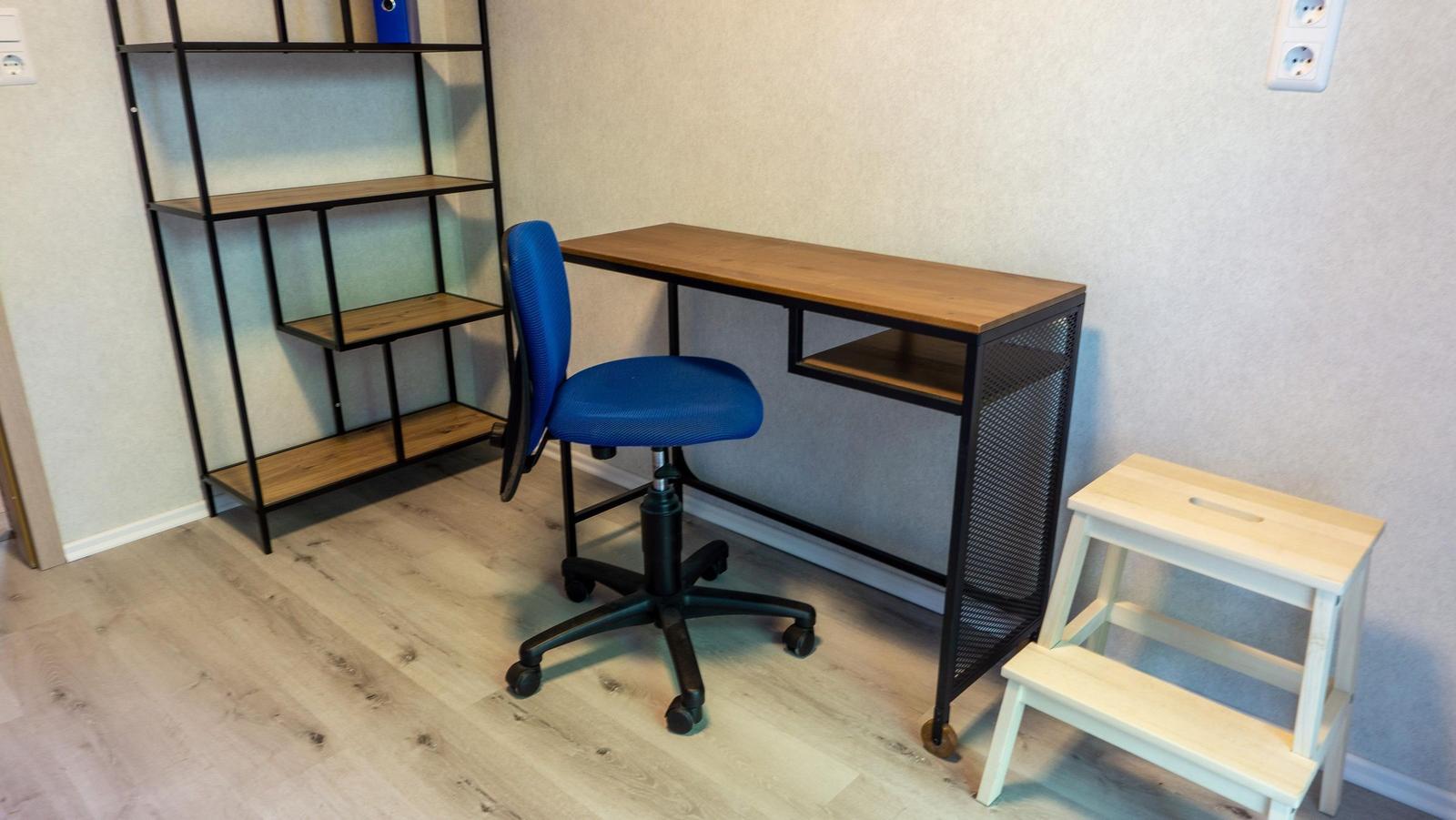 Schreibtisch mit Stuhl und Regal im Arbeitszimmer