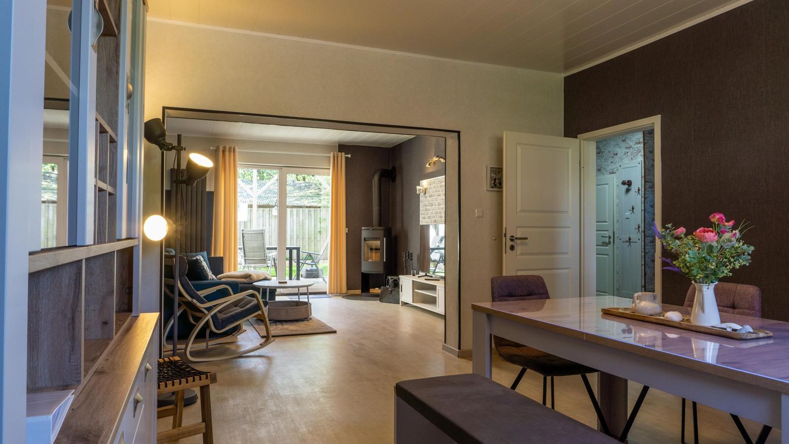 Wohn- und Essbereich mit Holzboden, Esszimmertisch und Blick auf Garten.