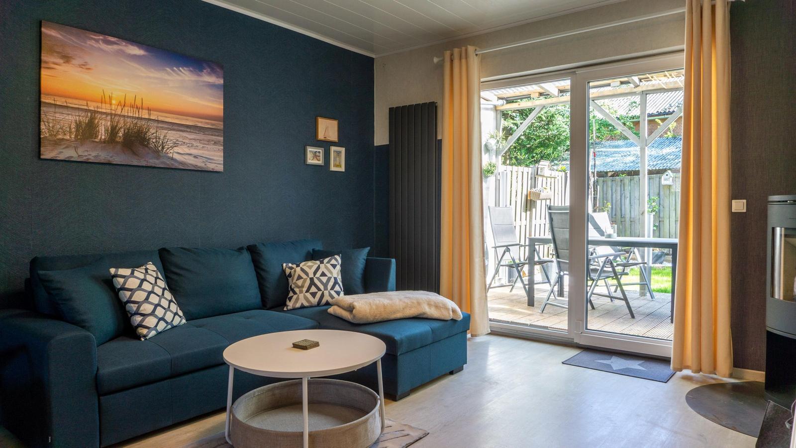 Wohnzimmer mit Sofa, Couchtisch und Blick auf Terrasse