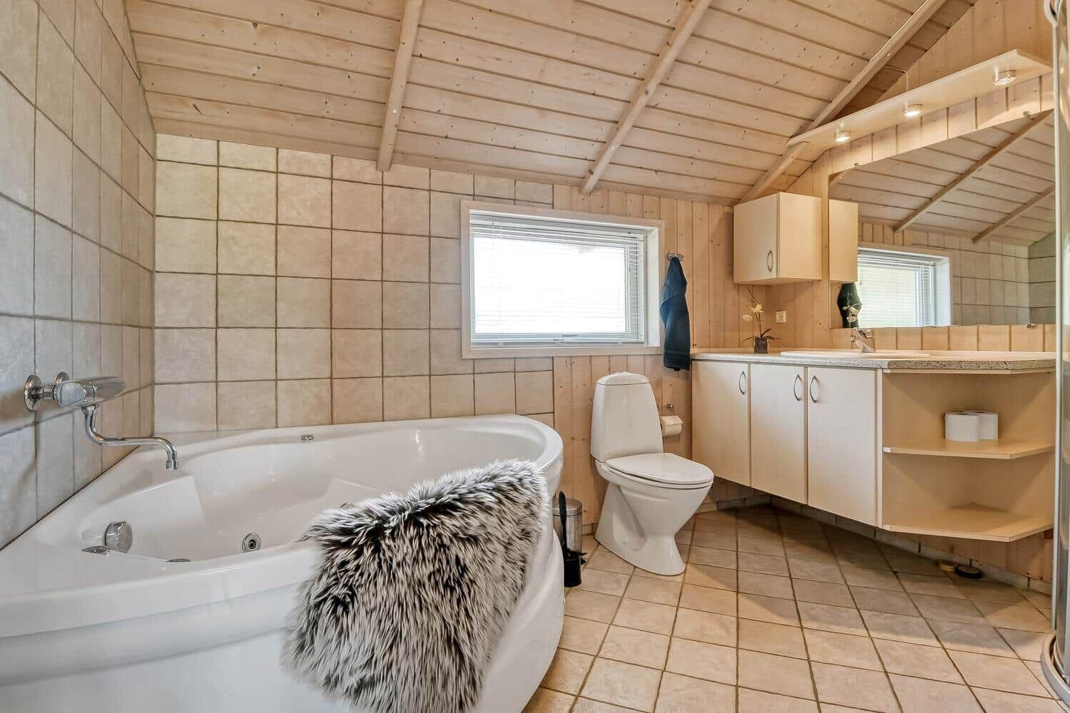 Badezimmer mit Badewanne, Toilette und Waschbecken.