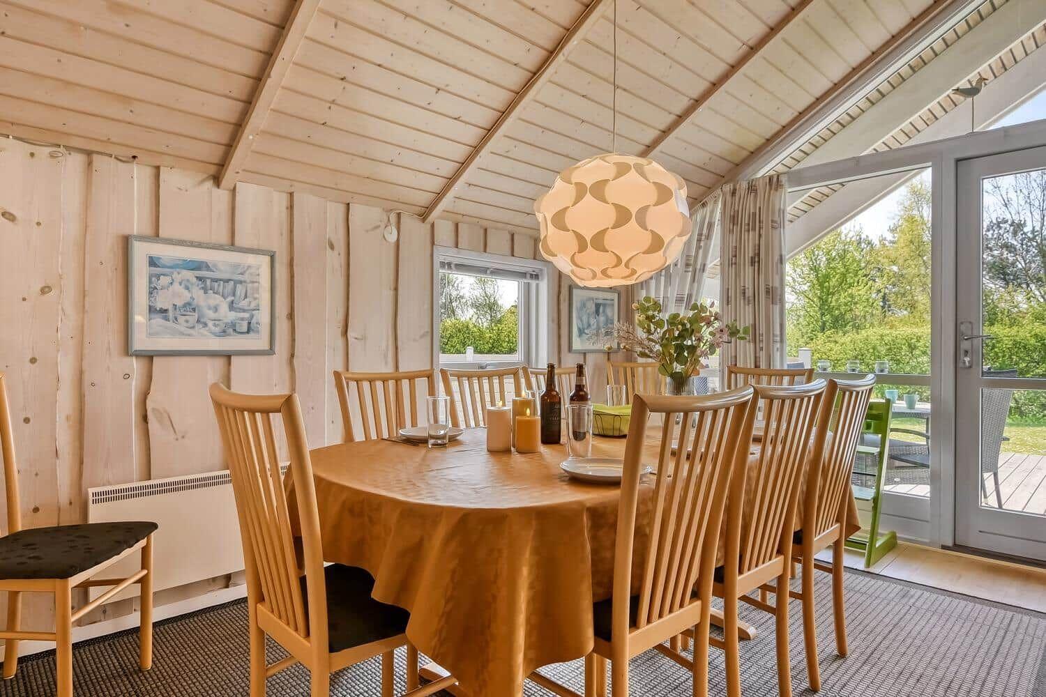 Esszimmer mit Holztisch, Stühlen und Fenster zur Terrasse