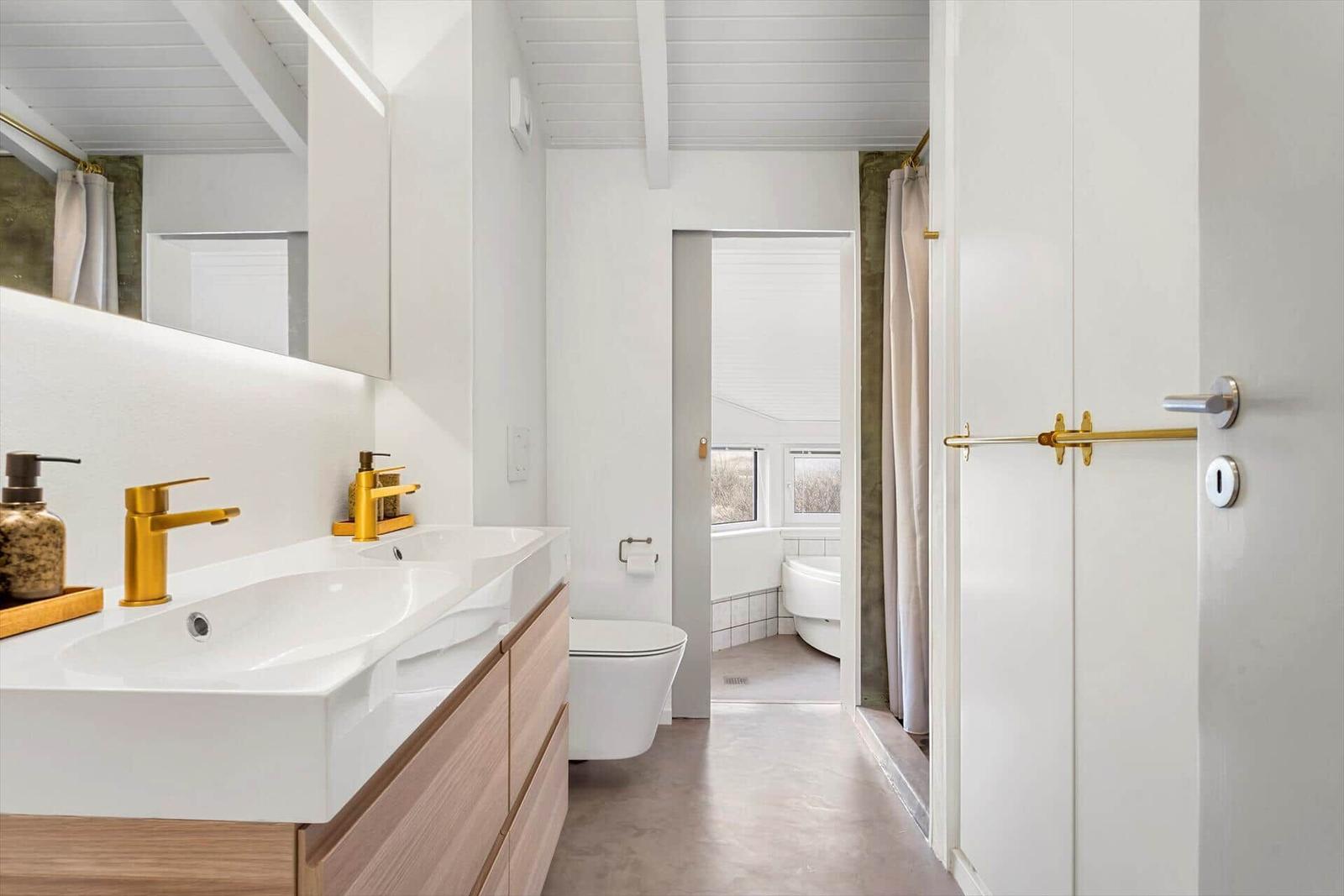 Badezimmer mit Waschbecken, Toilette und Badewanne.