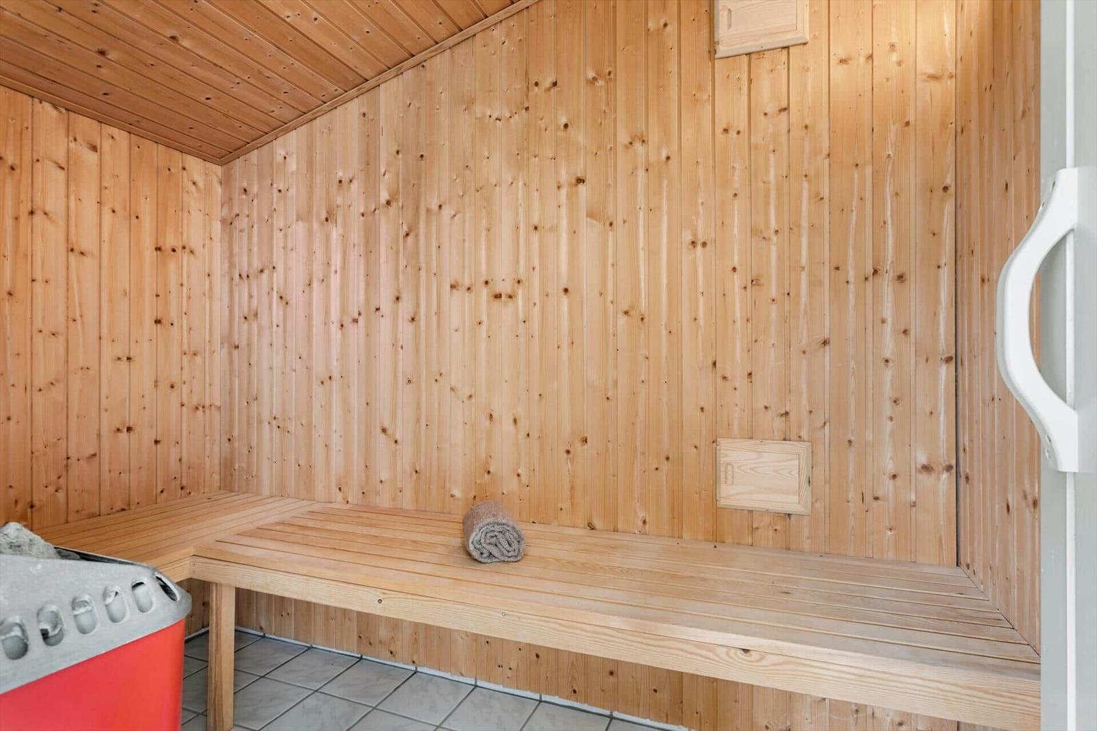 Sauna mit Holzwand, Bank und Handtuch