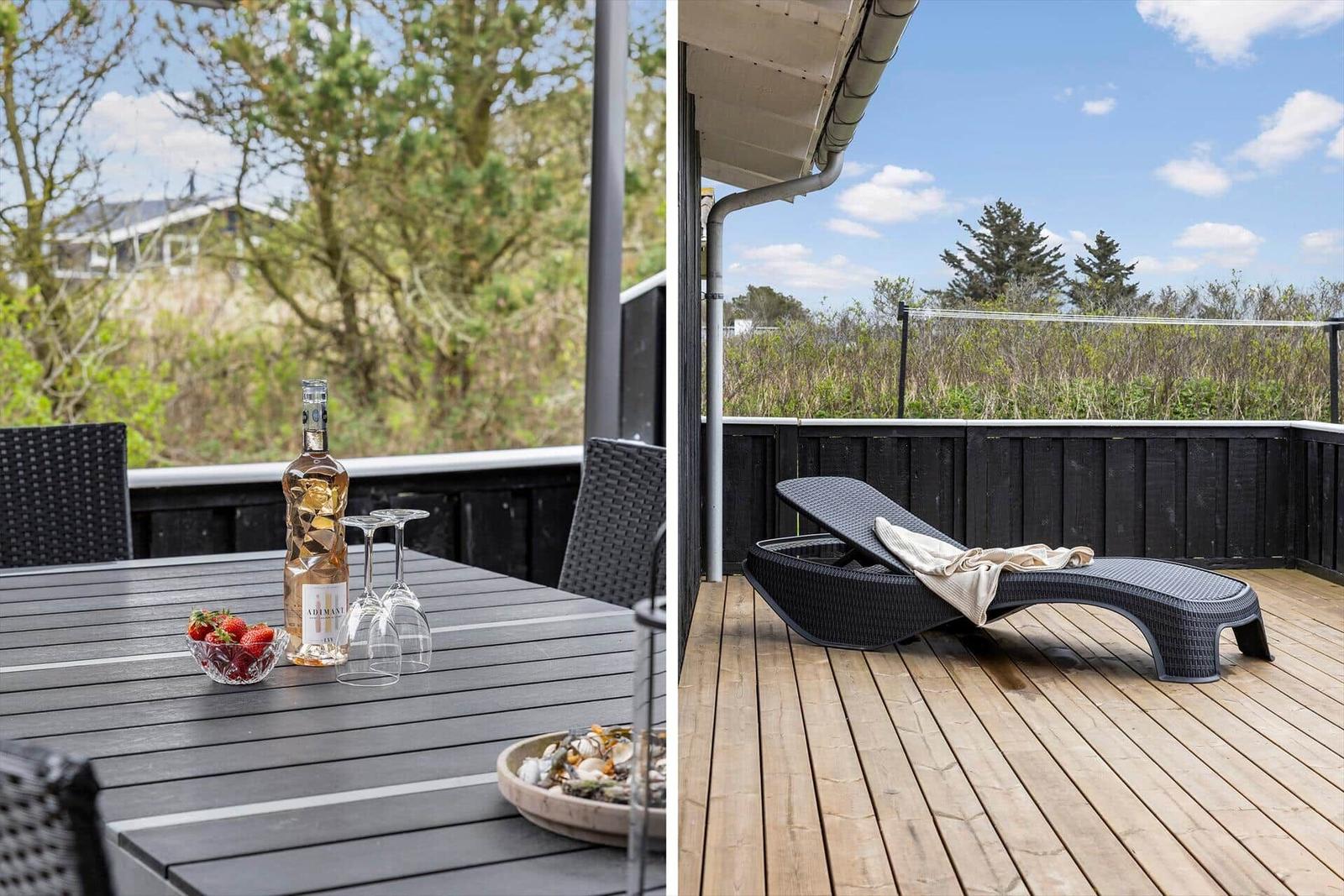 Terrasse mit Tisch, Stühlen und Liege. Hintergrund: Grünflächen und Himmel.