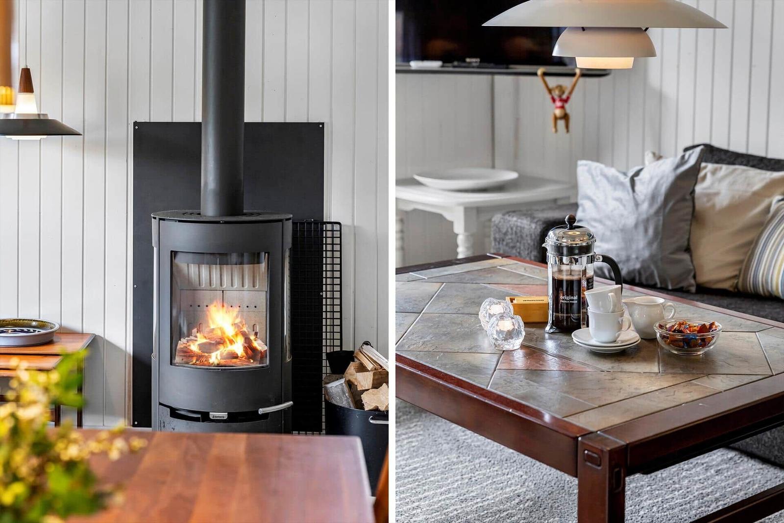 Kamin mit Holzfeuer und gemütlicher Sitzgelegenheit mit Tisch und Kaffeekanne.