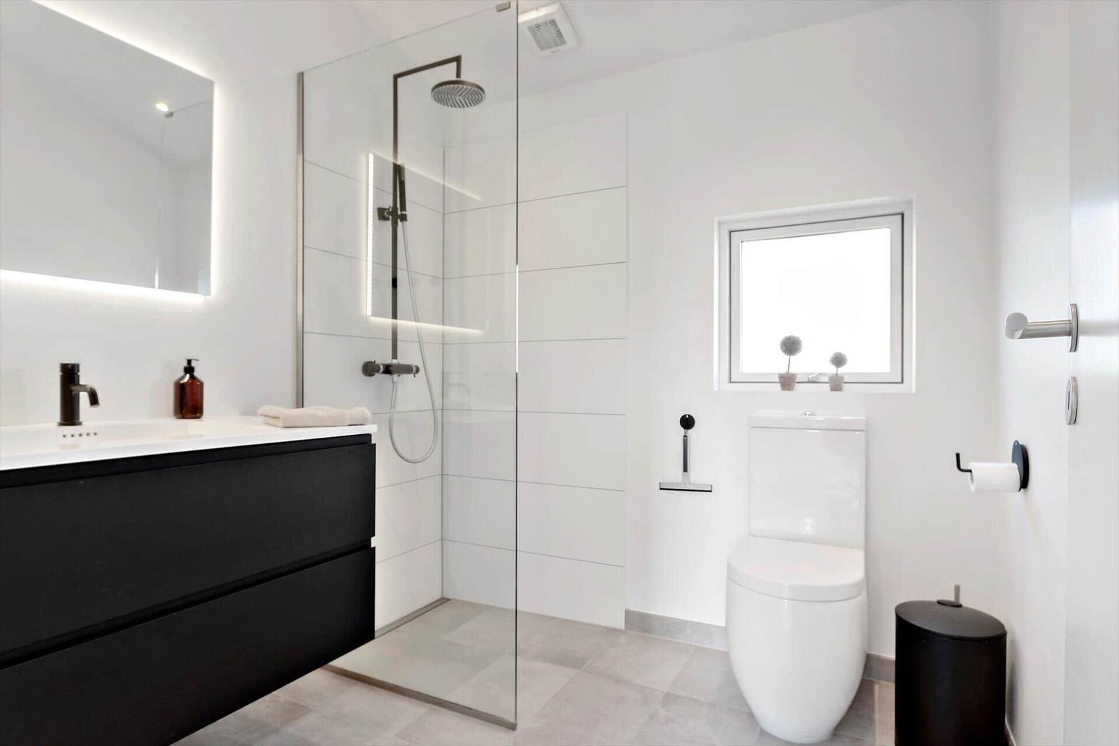 Moderne Badewanne mit Dusche, Waschtisch und Toilette.