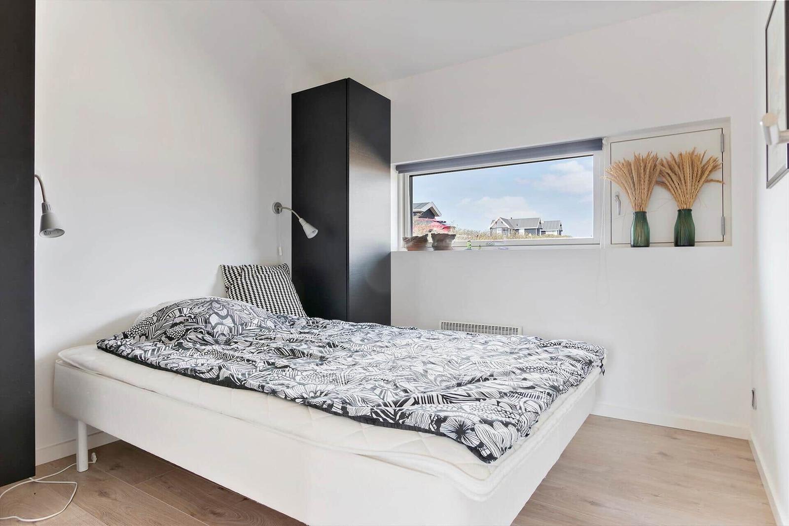 Schlafzimmer mit Bett, Fenster und Schrank.