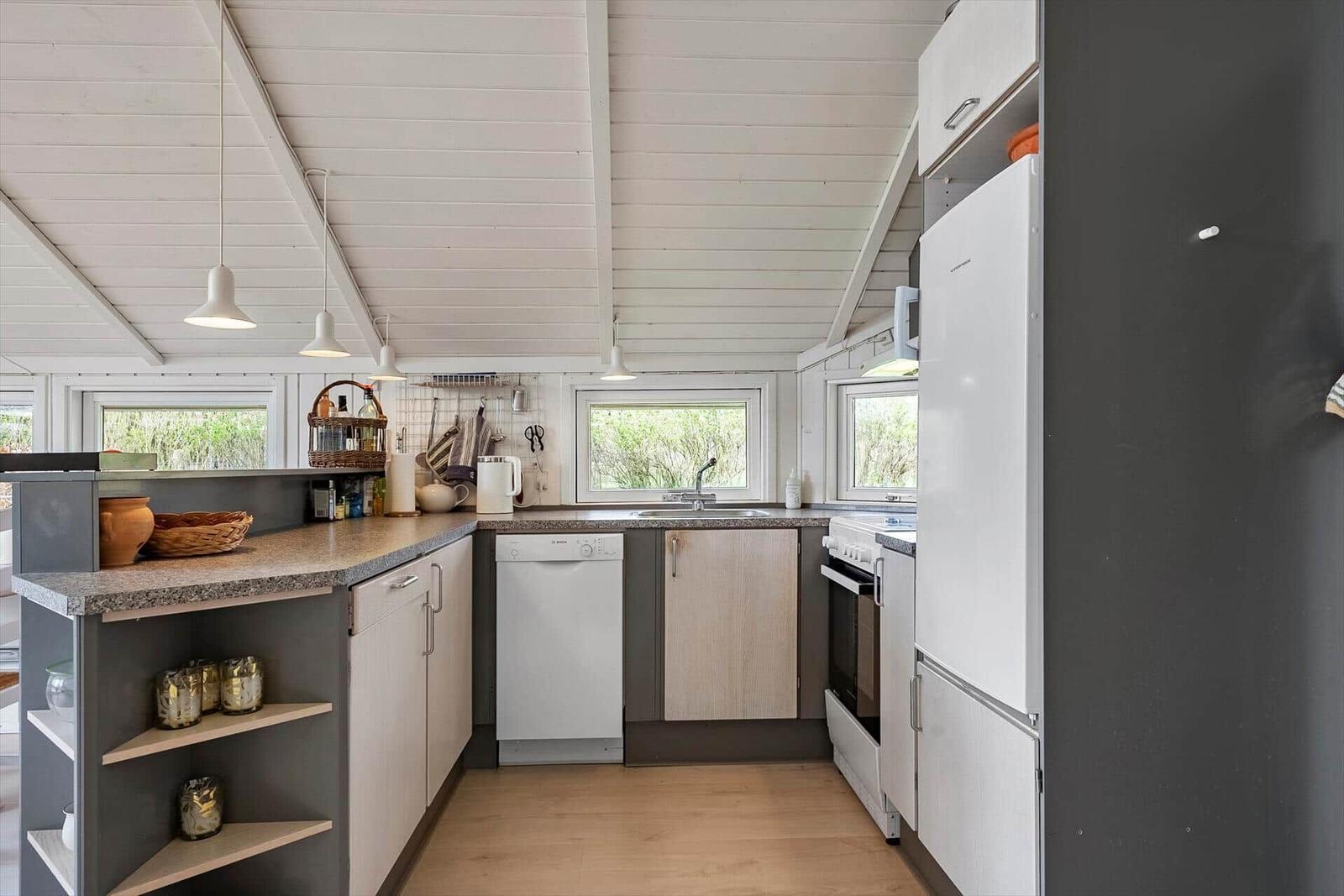 Küche mit Arbeitsplatte, Spüle, Kühlschrank und Waschmaschine.