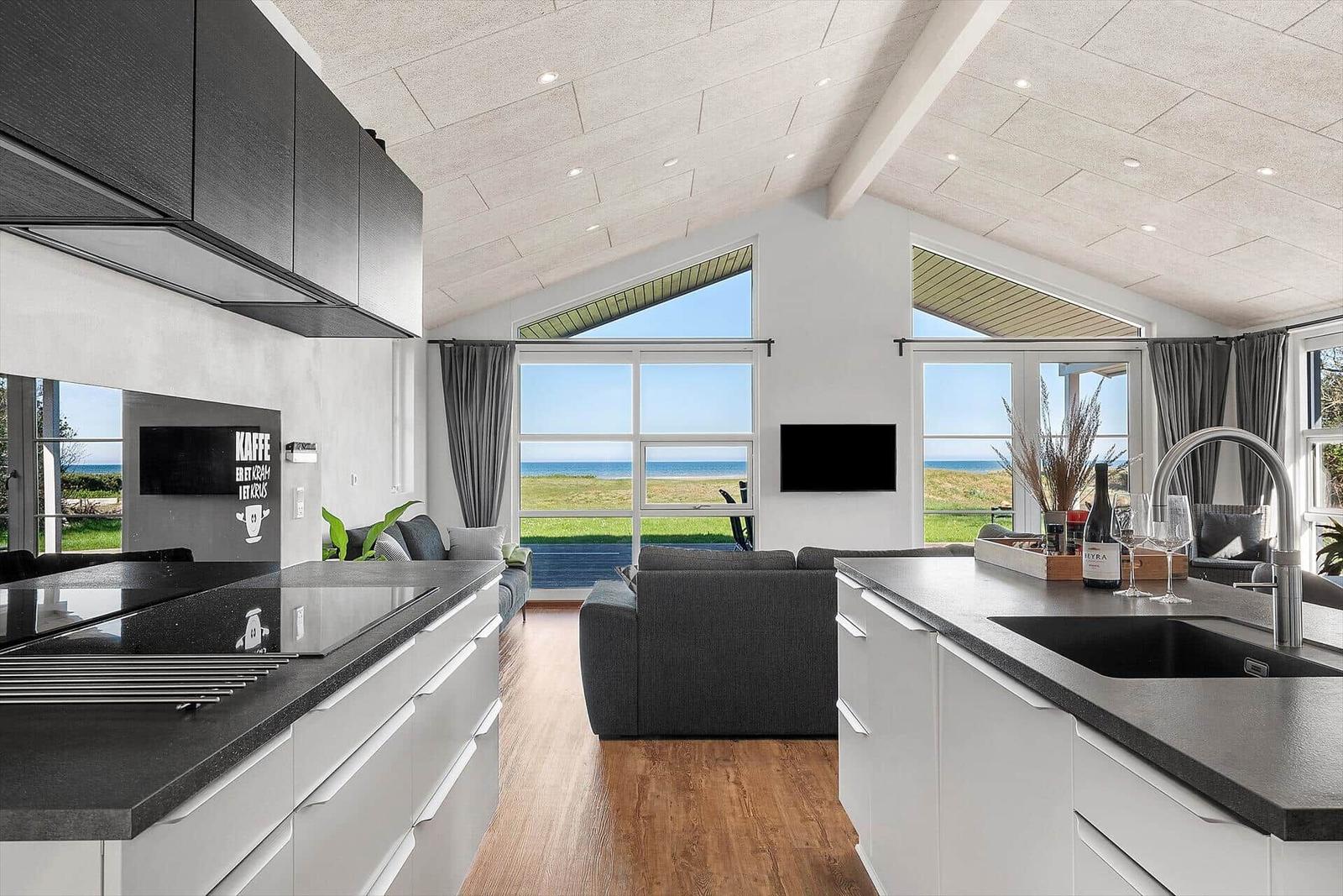 Küche mit Blick auf Strand und Grünland. Moderne Einrichtung mit Kücheninsel.