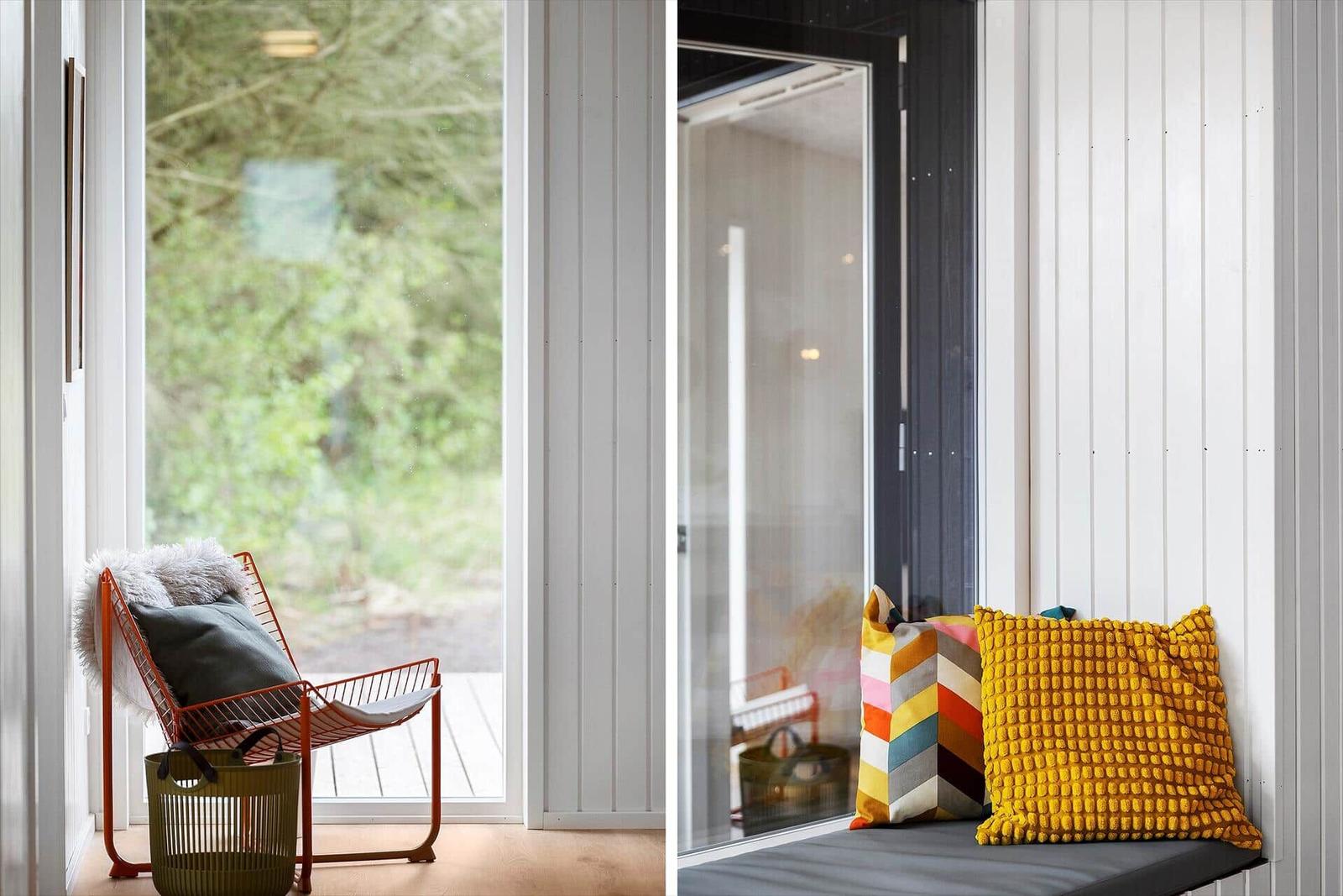 Ein Fensterblick auf Grün mit einem orangefarbenen Stuhl und einem Fensterbrett mit Kissen.