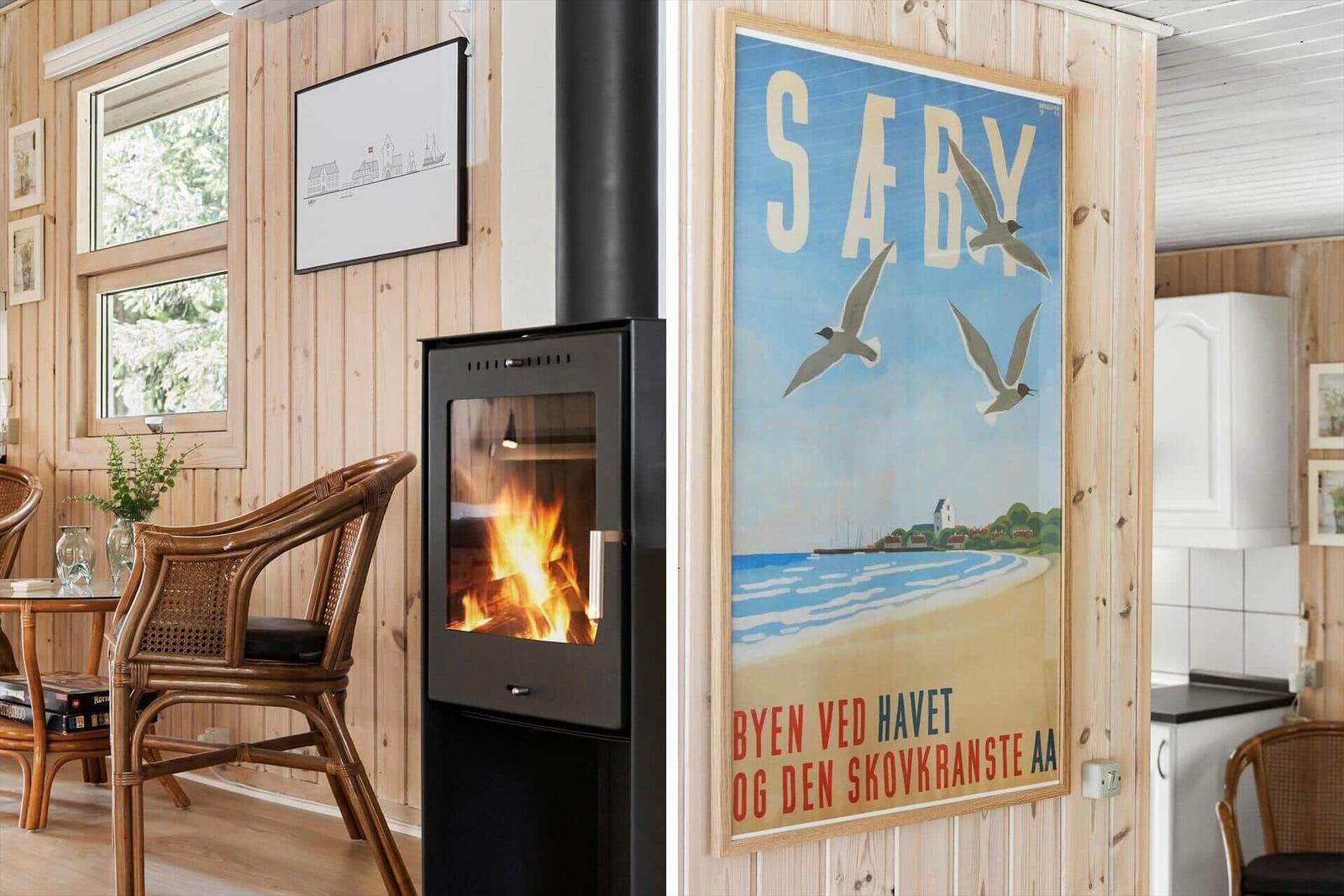 Wohnraum mit Kamin, Wandbild und Holzwandverkleidung