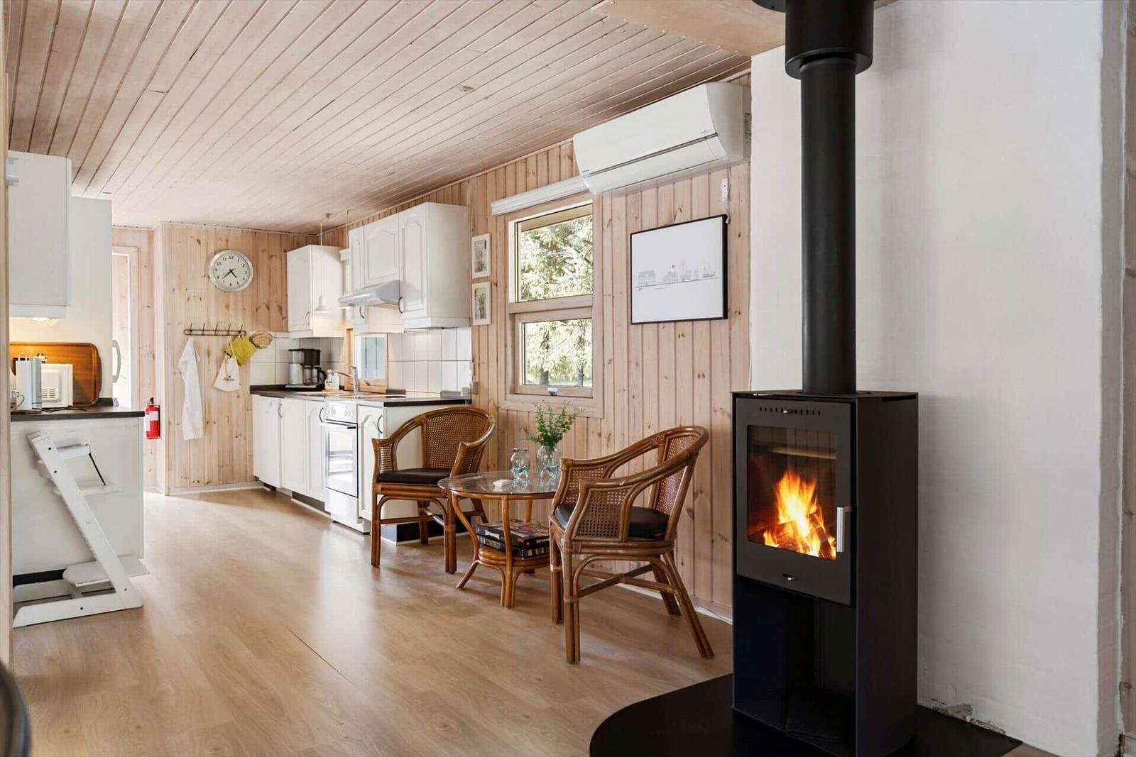 Küche mit Essbereich und Kaminofen. Holzwände und -boden.