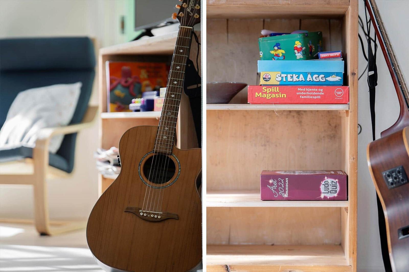 Akustische Gitarre und Brettspiele auf einem Holzregal.
