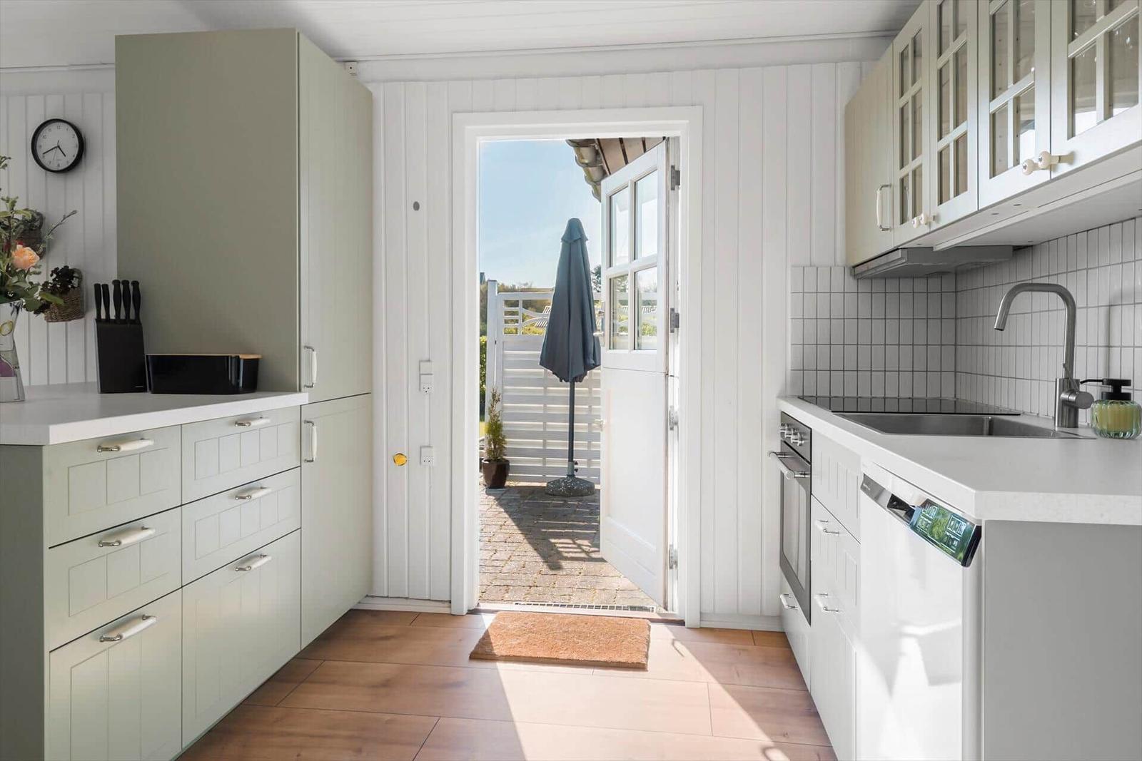 Kitchen with white cabinets and view to the terrace.