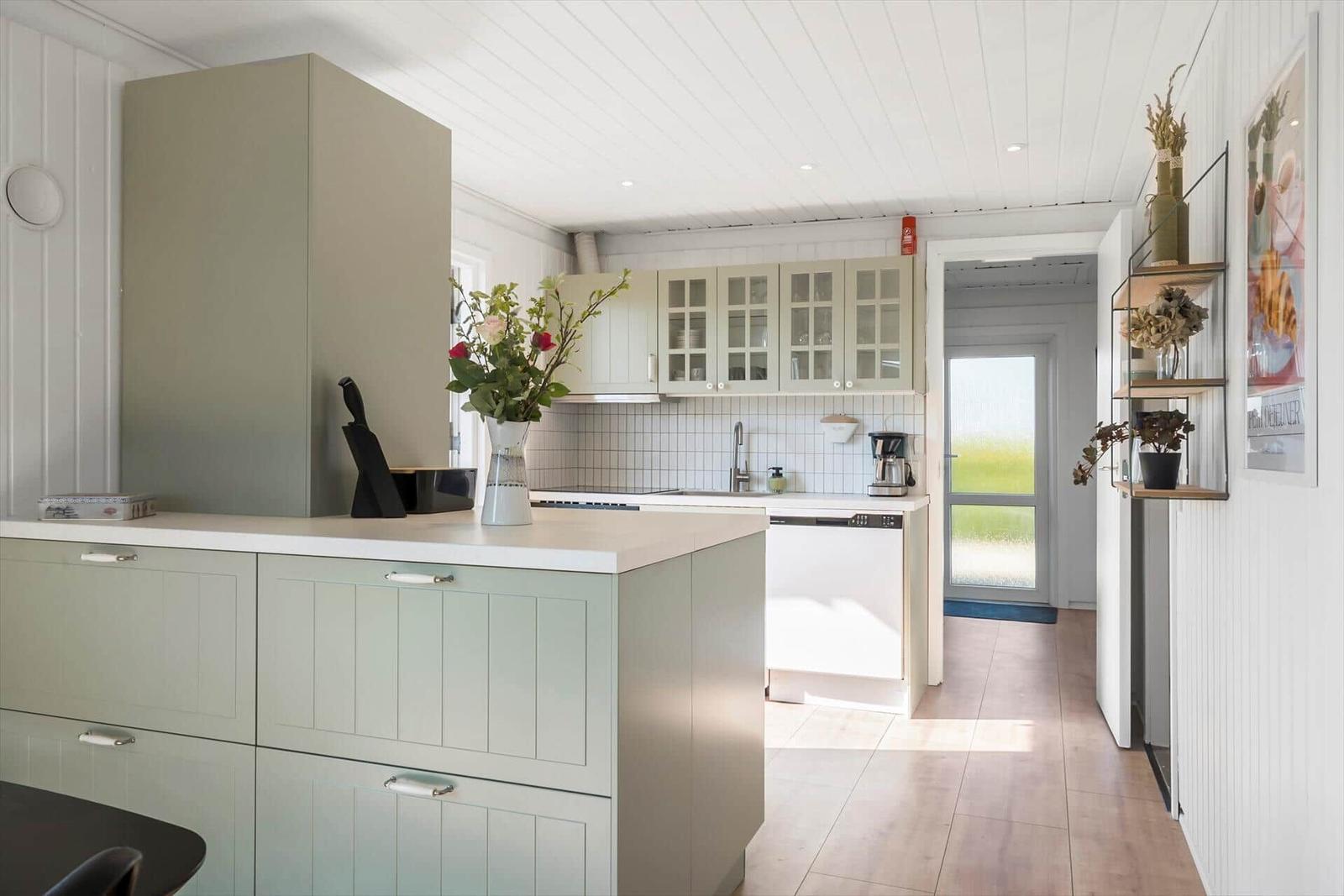 Kitchen with light cabinets, countertop, and window view.
