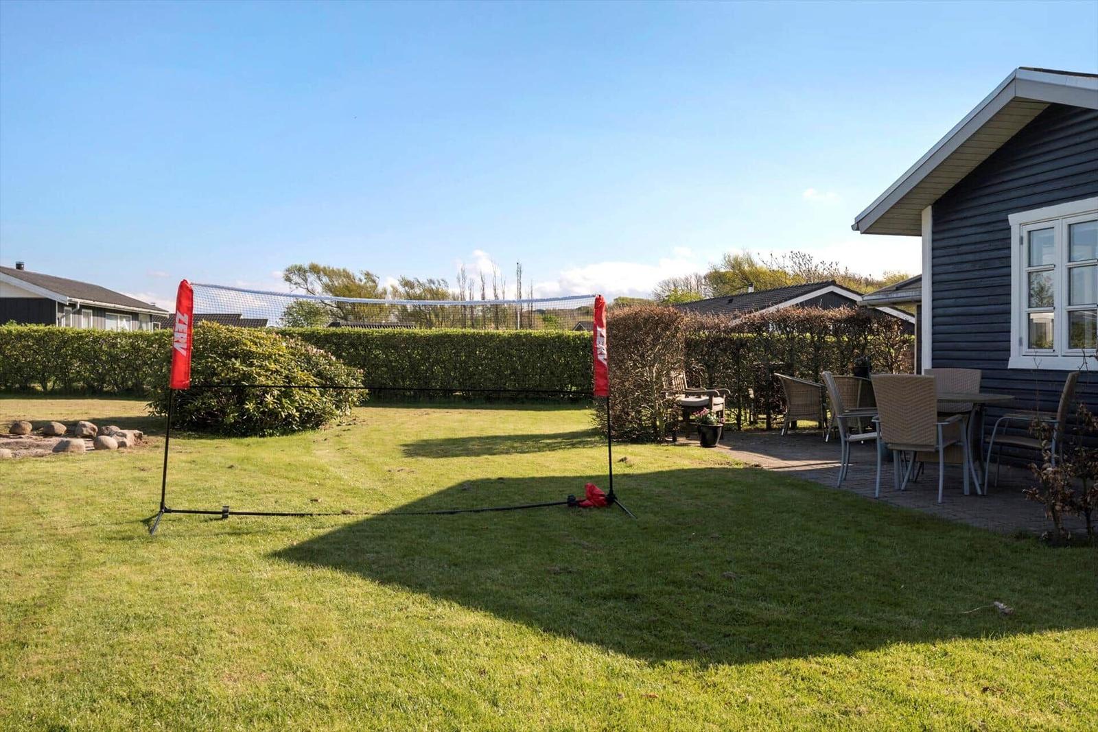 Garden with volleyball net, seating group, and terrace by house