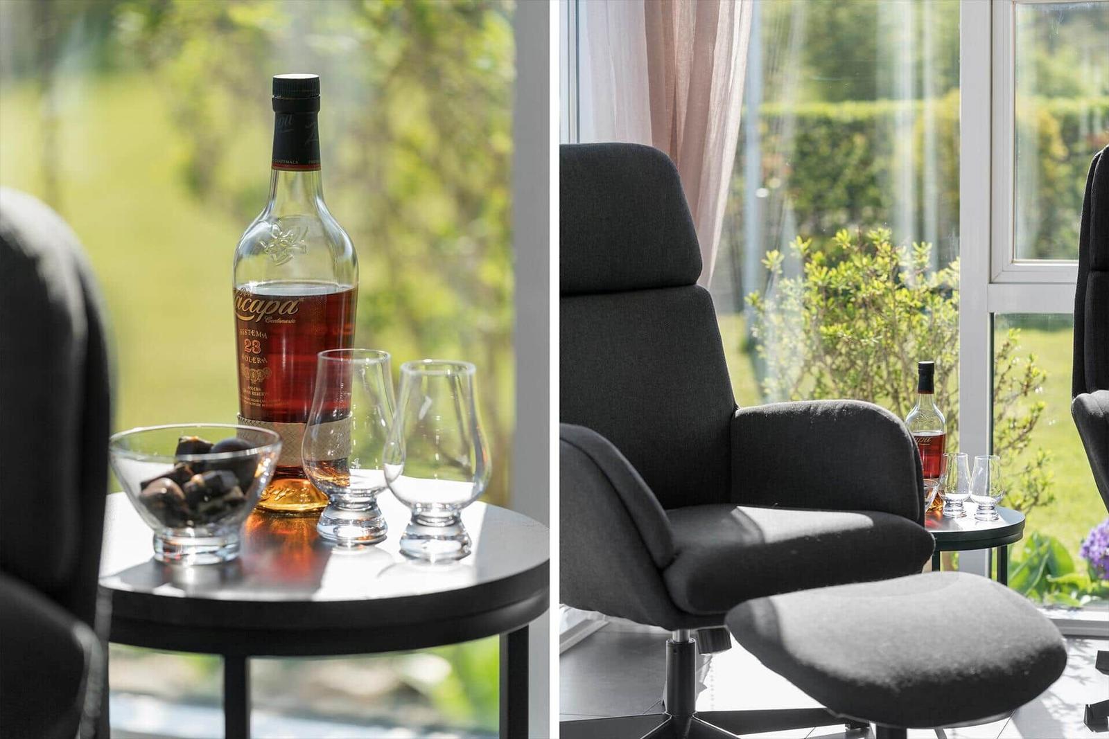 Seating area with whisky and glasses by large window