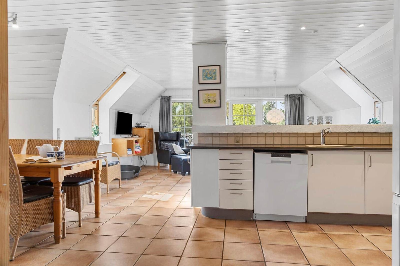 Küche mit Essbereich und Wohnbereich unter Dachschrägen.