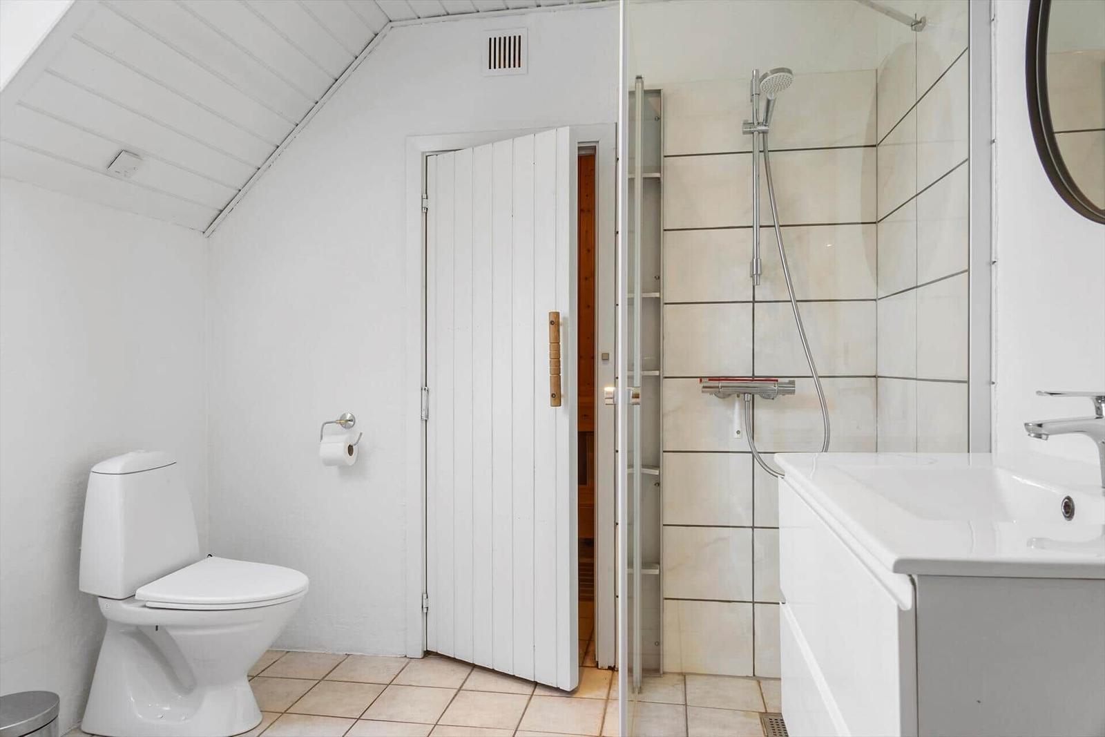 Badezimmer mit Dusche, Toilette und Waschbecken