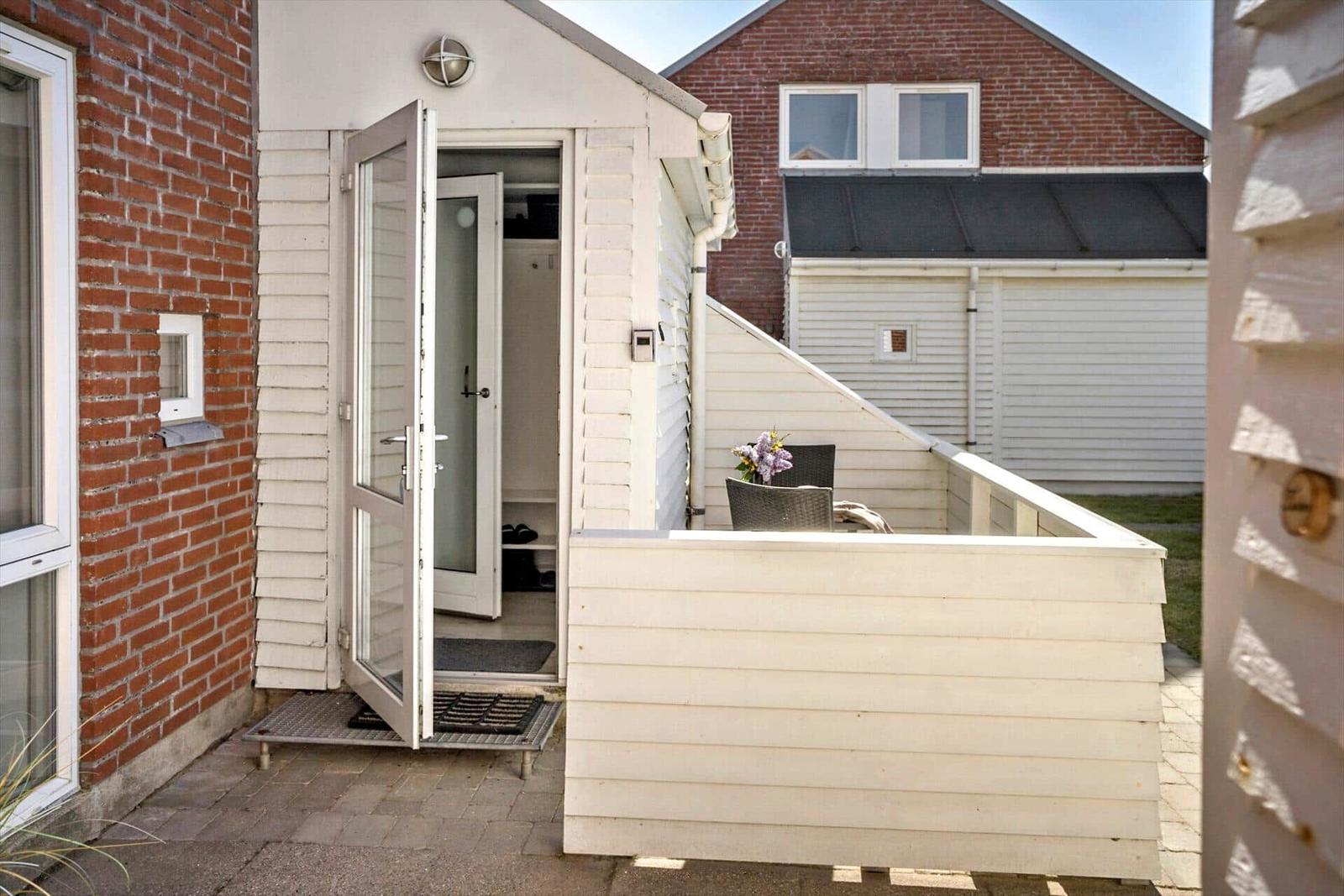 Haus mit Terrasse, offener Eingang und Gartenbereich