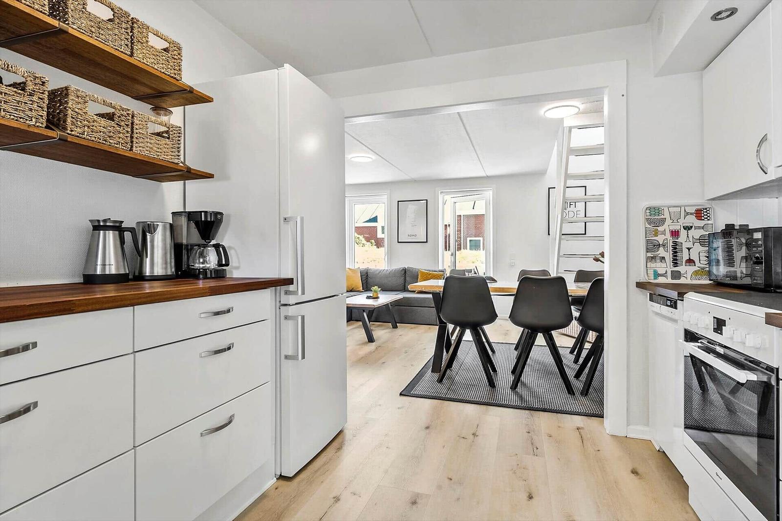 Küche mit Essbereich und Wohnzimmer im Hintergrund.