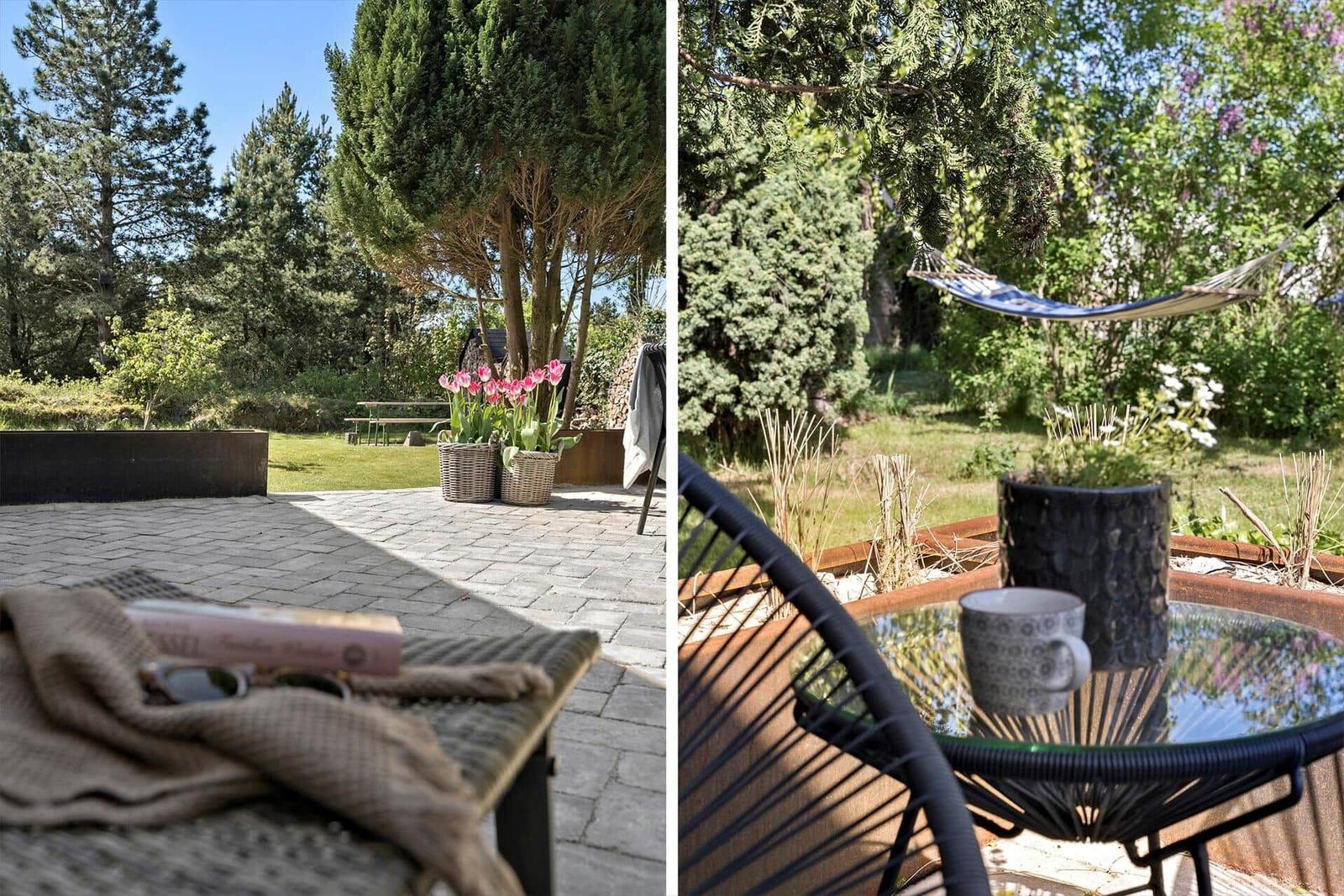 Terrasse mit Sitzgelegenheit und Blick auf Garten mit Bäumen und Tulpen.