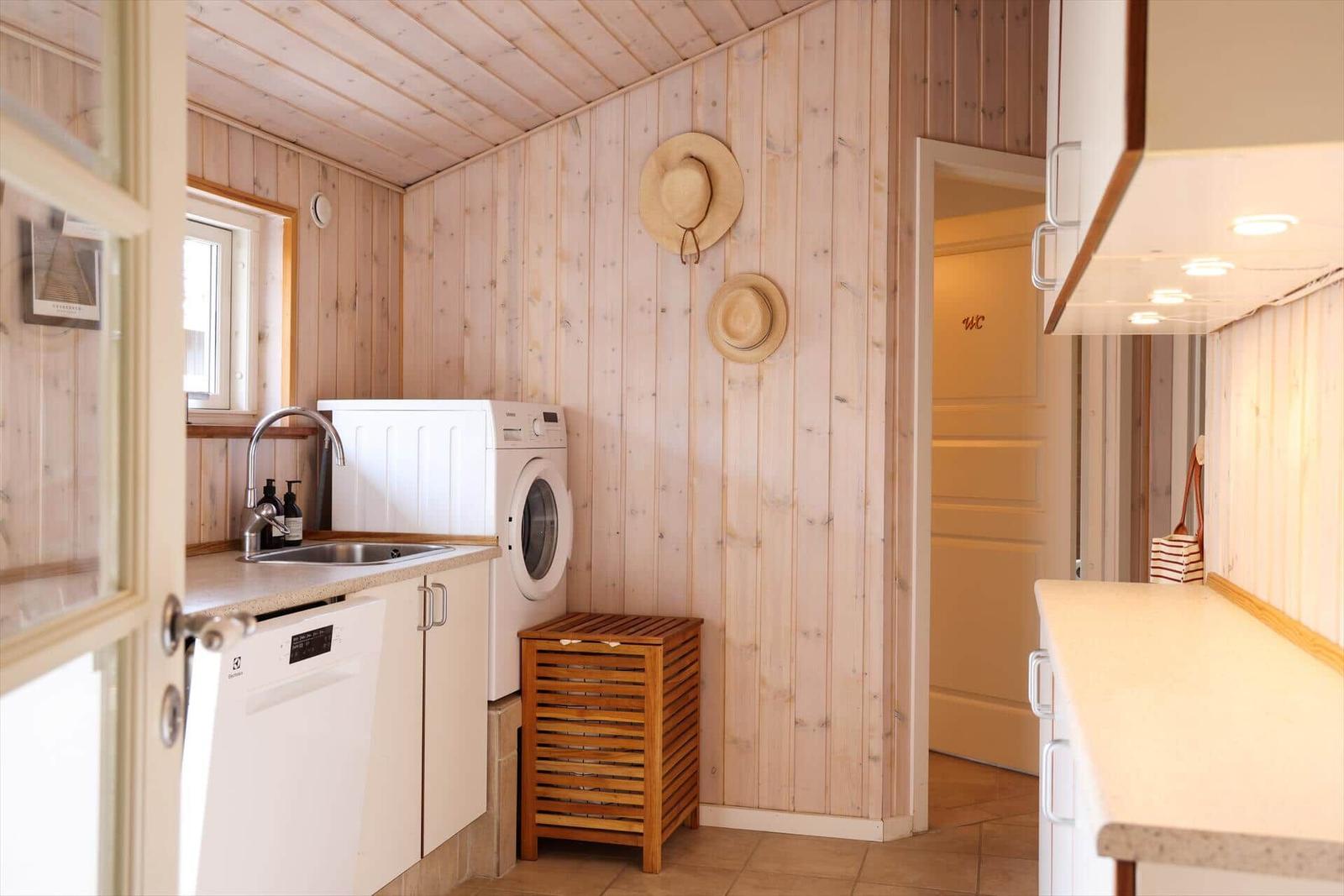 Kitchen with sink, washing machine, and WC door