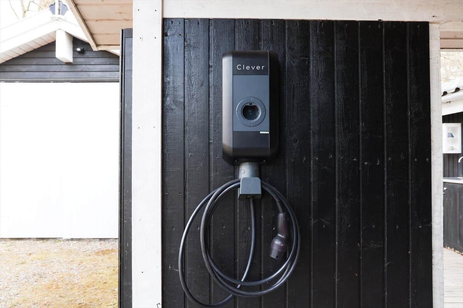 Charging station on black wooden wall with coiled cable