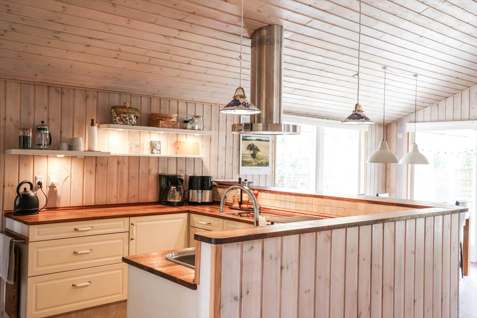 Kitchen with wooden walls, worktop, and kitchen island.
