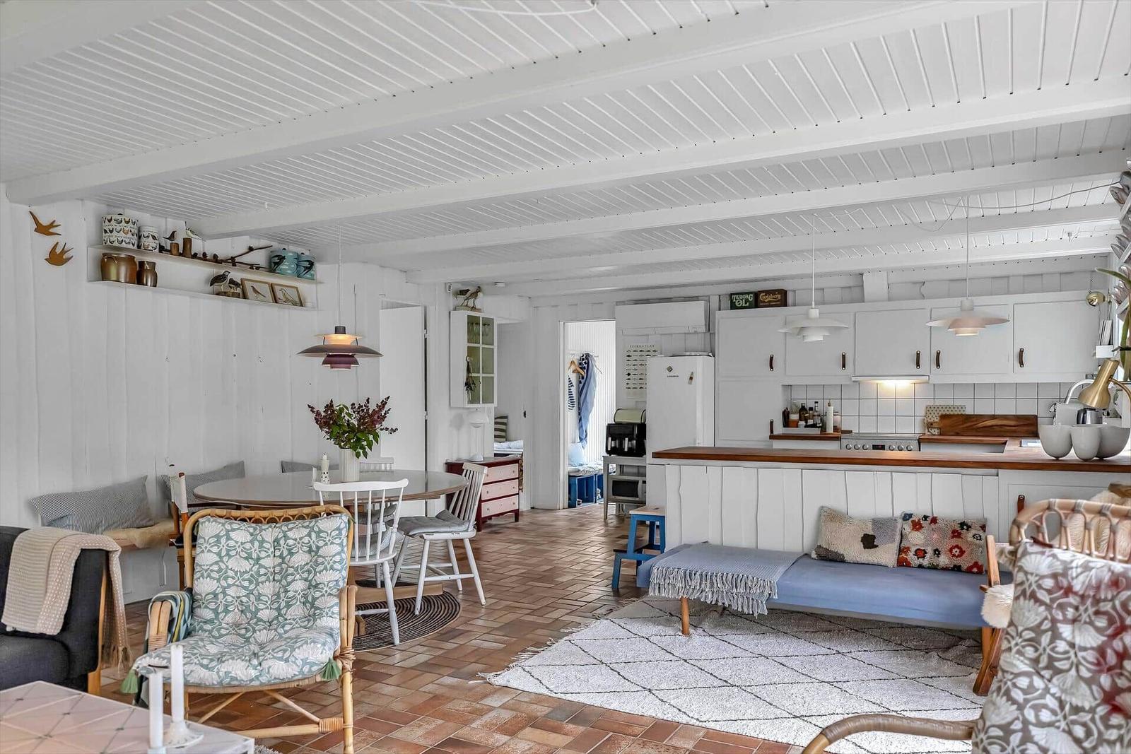 Wohnküche mit Essbereich und Sofa auf Terrakottboden