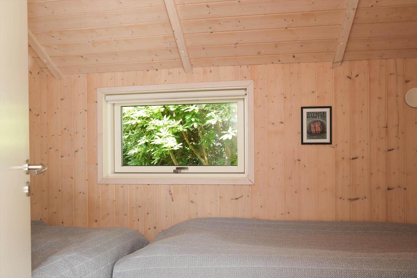 Schlafzimmer mit Holzwand, Fenster und Bett