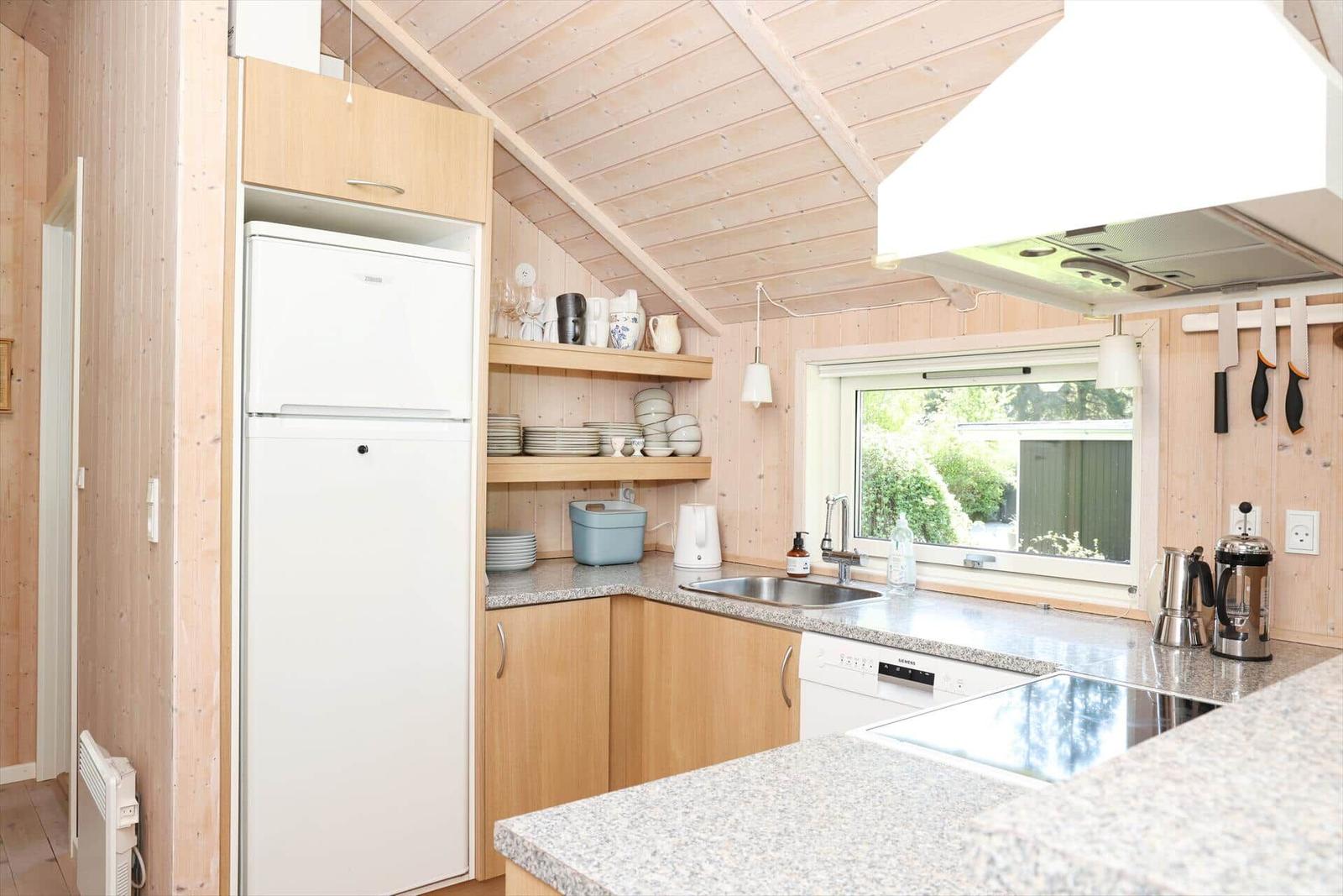 Küche mit Kühlschrank, Spüle und Fenster