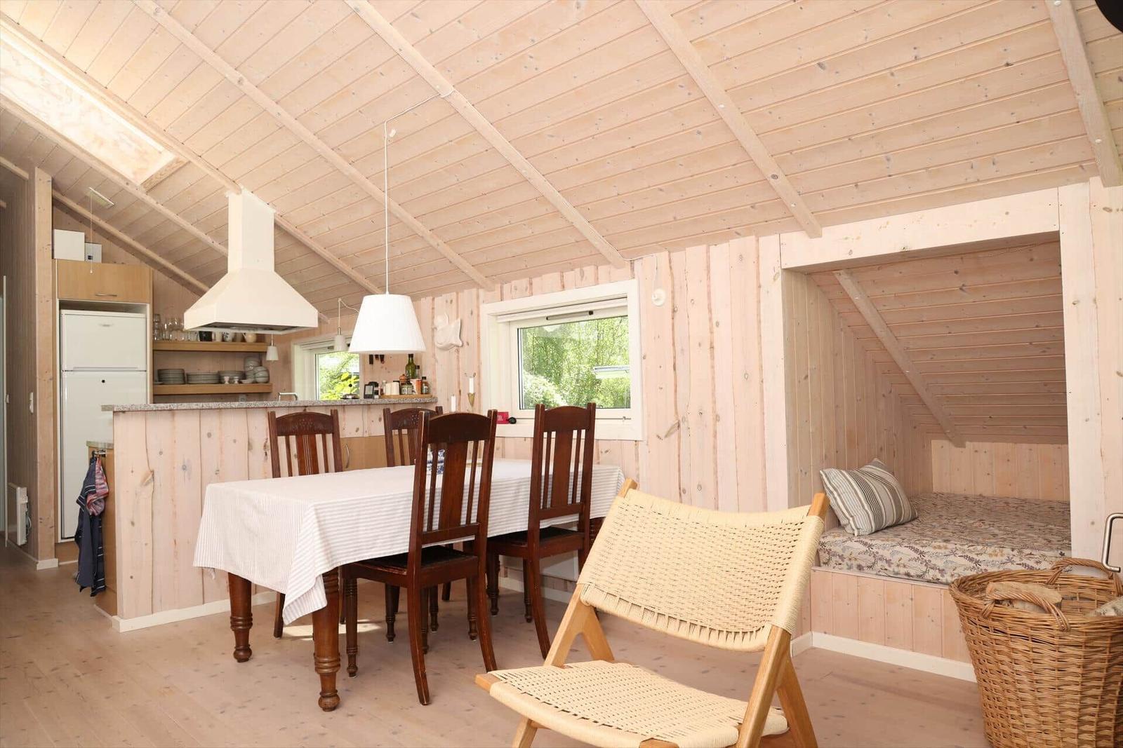 Küche mit Esstisch, Schlafgelegenheit und Fenster.