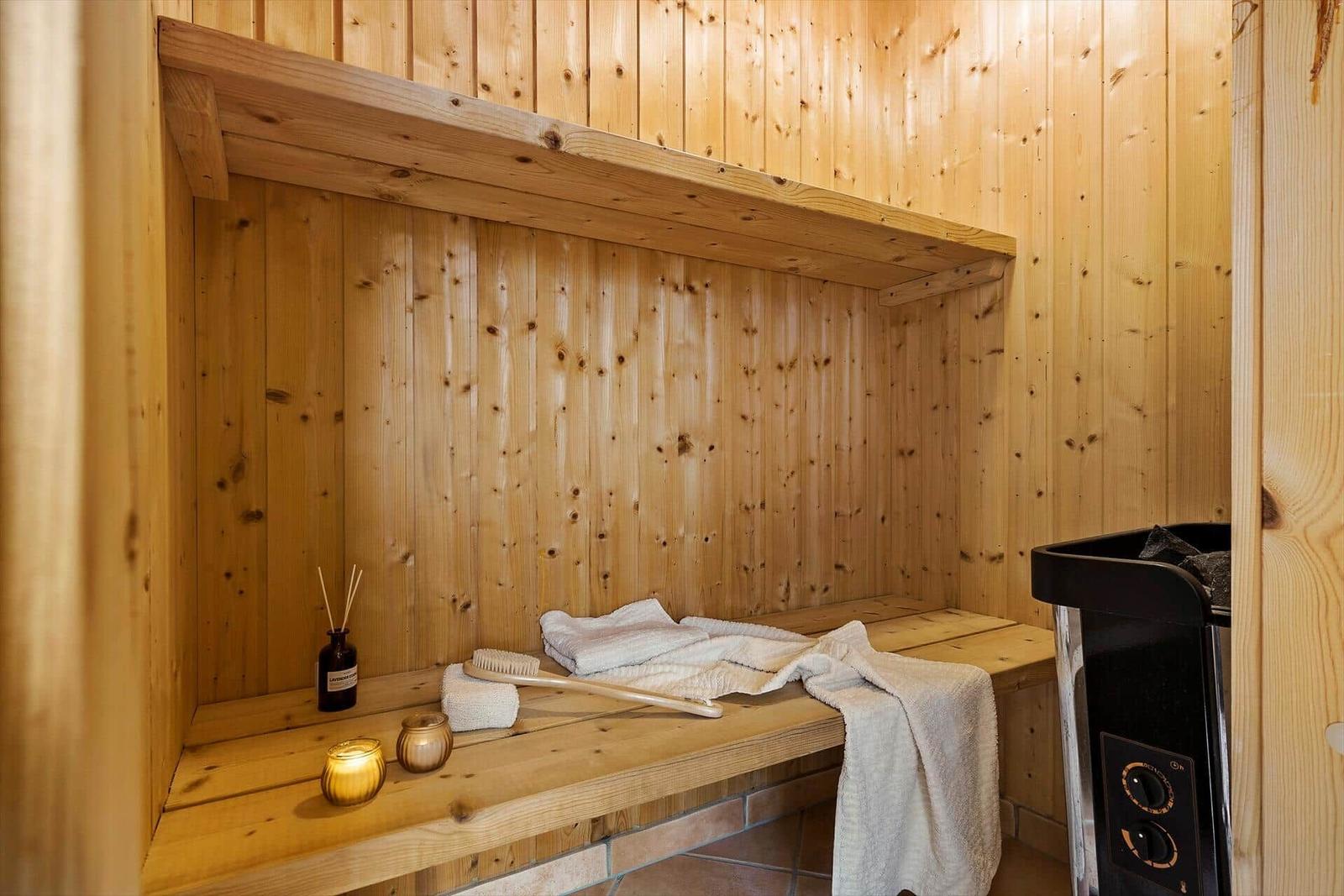 Sauna mit Holzwand, Bank, Handtuch und Heizgerät.
