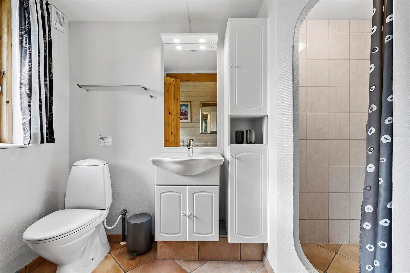 Badezimmer mit Toilette, Waschbecken und Dusche.