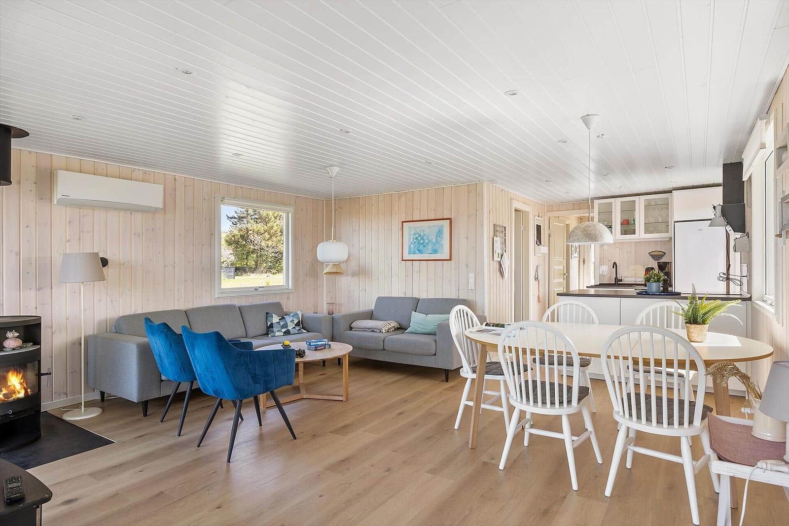 Wohn- und Essbereich mit Sofa, Esstisch und Kamin.