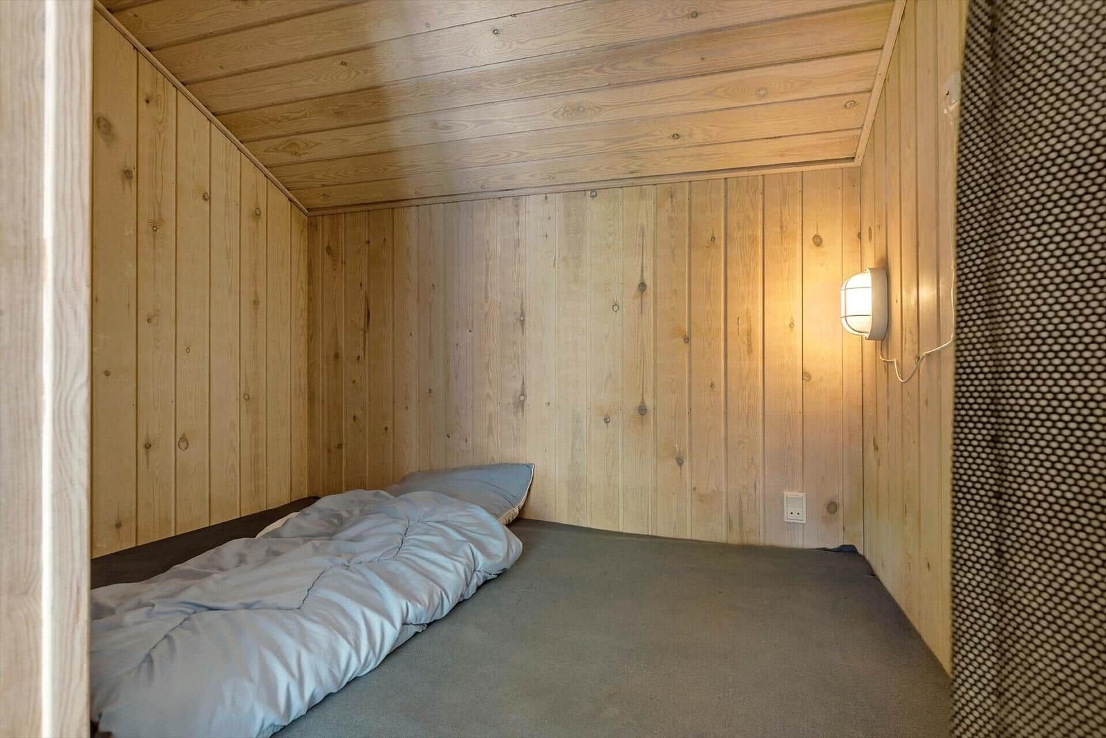 Ein Schlafzimmer mit Holzwänden und einem Bett mit Bettwäsche.