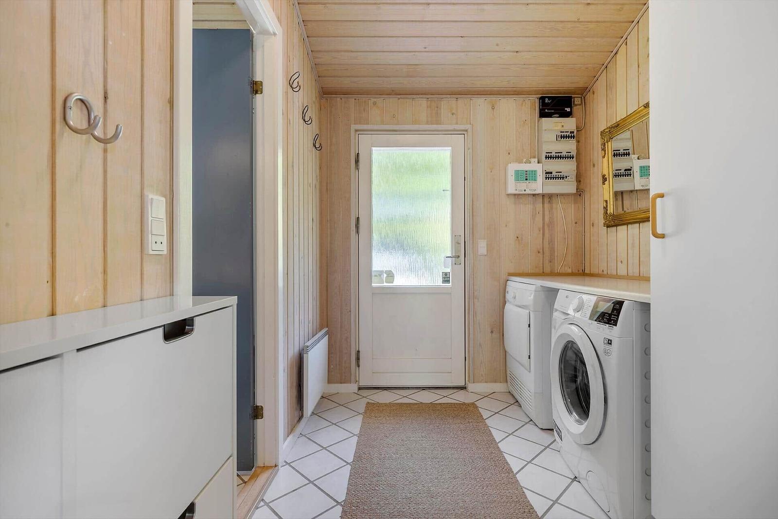 Wohnung mit Waschmaschine und Trockner, Holzwand und Fliesenboden.