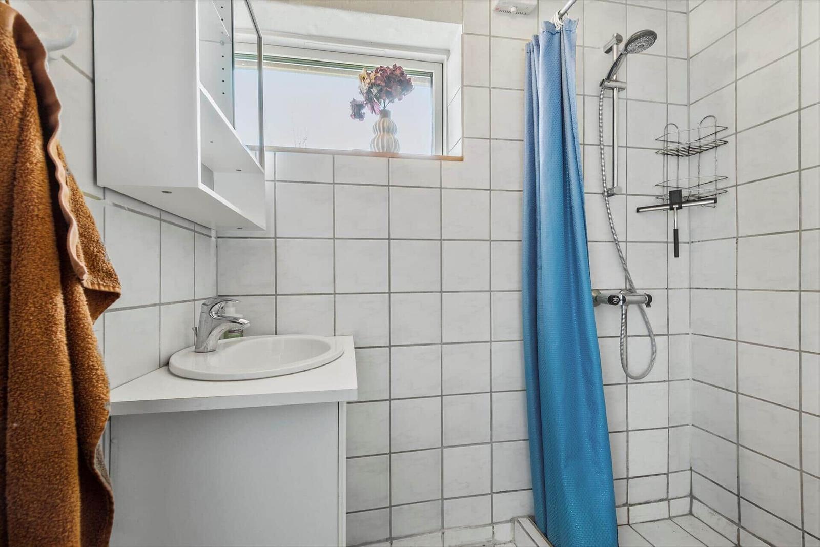 Bathroom with shower, sink, and window