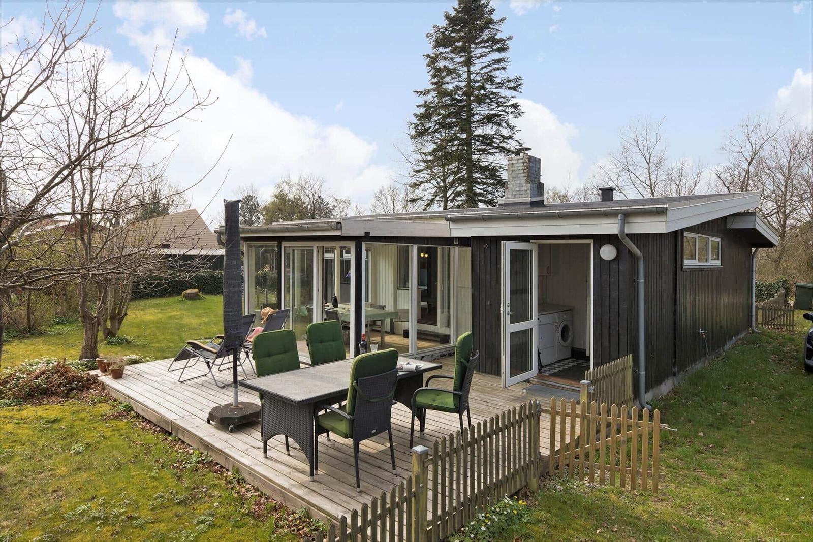 Modern villa with terrace, grill area, and garden. Living area with glass wall.