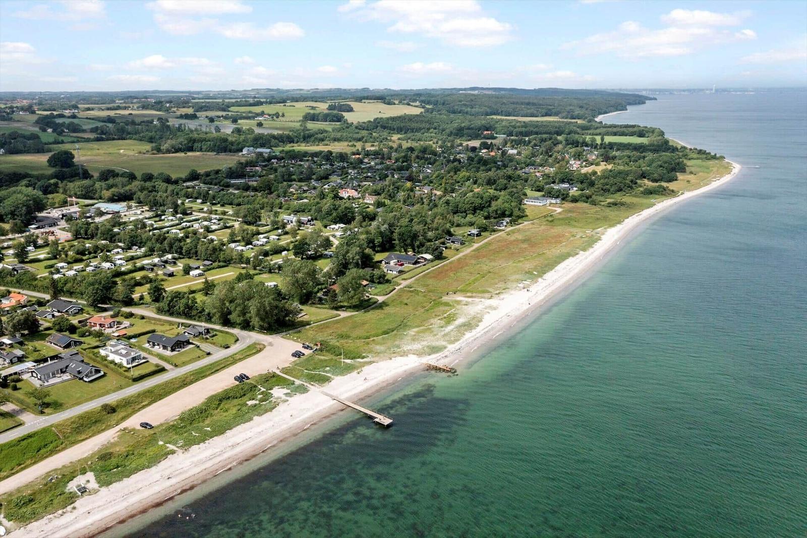 Strandnahe Siedlung mit Wohnhäusern und Campingplatz an der Küste.