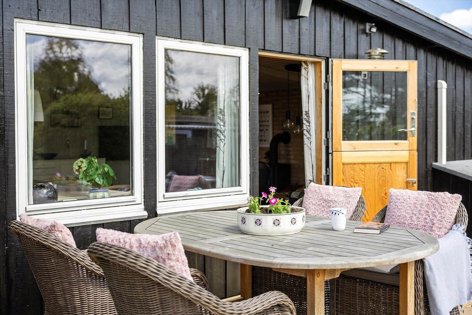 Terrasse mit Tisch und Stühlen, Blick in das Haus.