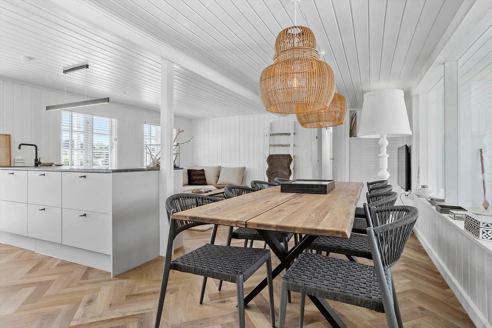 Essbereich mit Holztisch und Stühlen, Küche mit Arbeitsplatte und Fenster