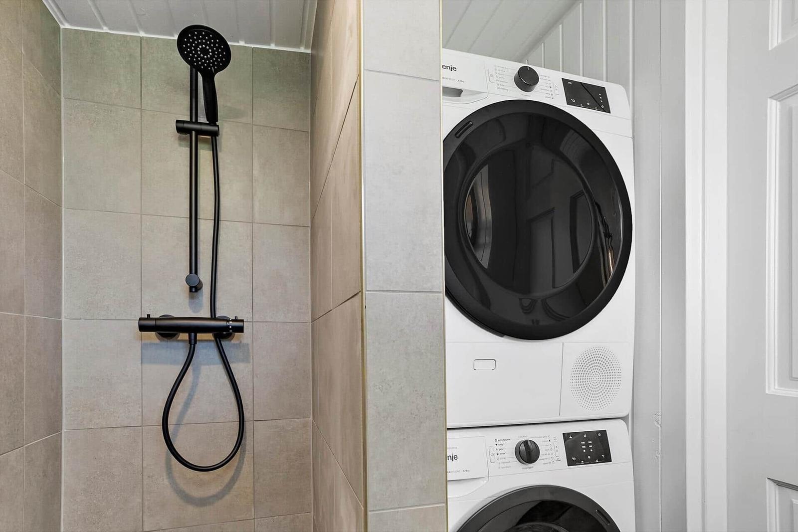 Dusche mit Duschbrause und Waschmaschine-Trocknerkombination